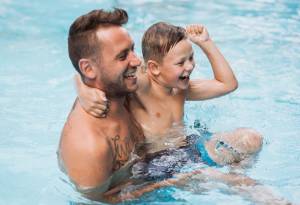 Vater und Sohn beim spielen im Hotelpool