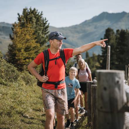 Vater zeigt beim Wandern die Umgebung vom Zillertal seiner Familie