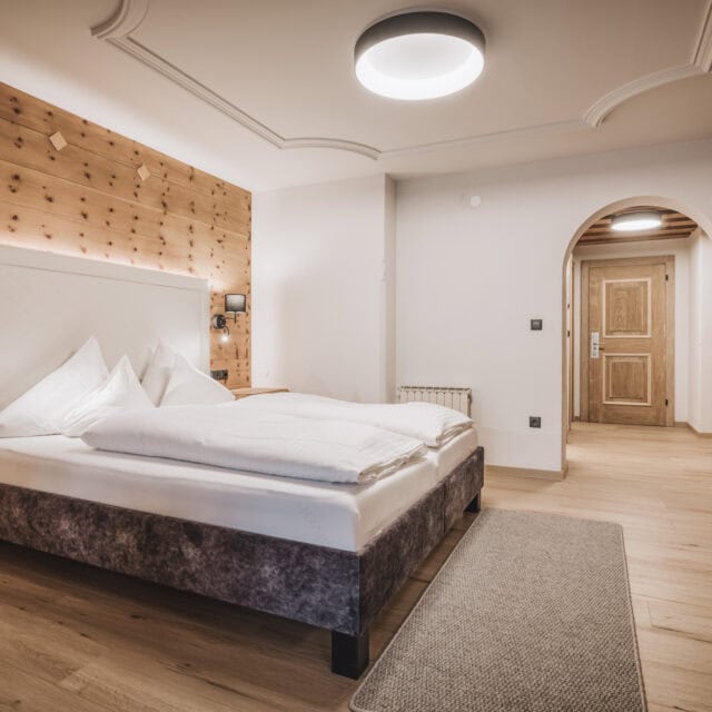 juniorsuite kirchspitz7 Modernes Schlafzimmer mit Holzdetails und Bett.