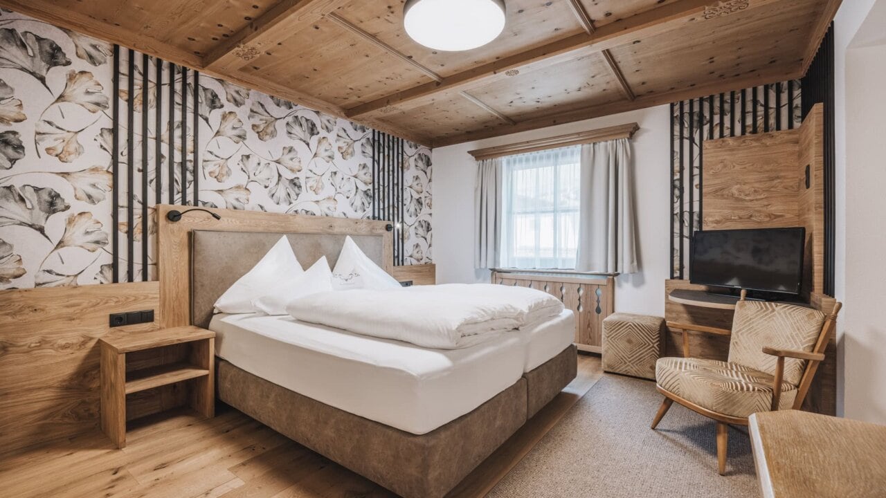 Gemütliches Schlafzimmer mit Holzdekor und Pflanzenmotiv.