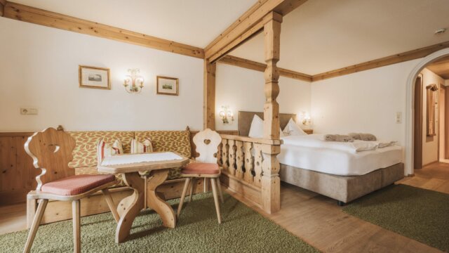 Helles Zimmer mit Holzdekor und gemütlicher Sitzecke.