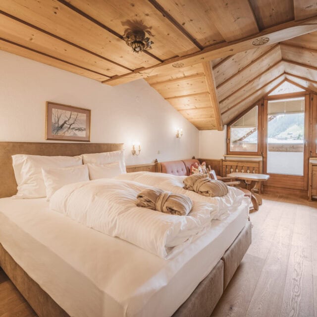 doppelzimmer zillertal8 Gemütliches Schlafzimmer mit Holzdecke und Fenster.