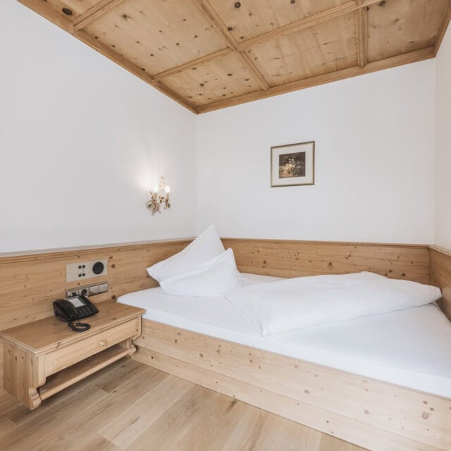 einzelzimmer de luxe2 Gemütliches Zimmer mit Holzdekor und Schlafgelegenheit.