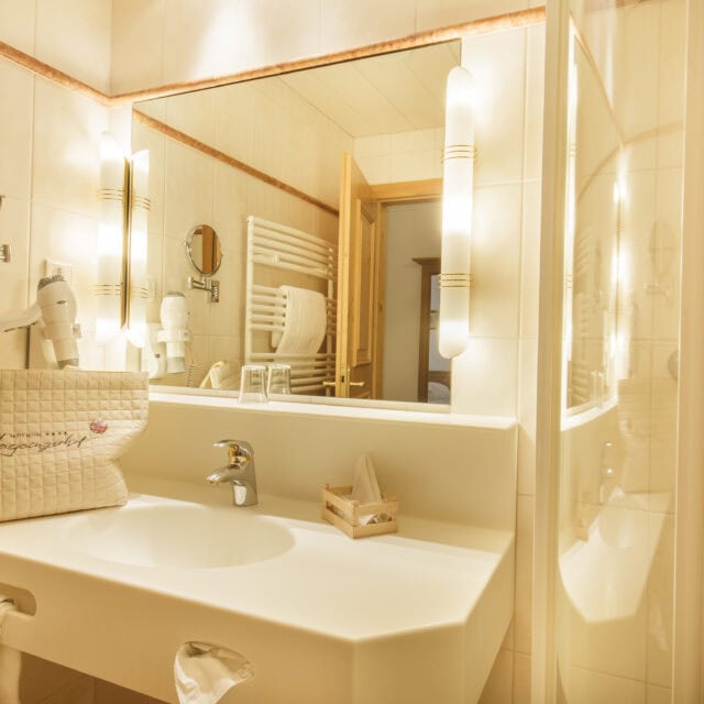 Helles Badezimmer mit Spiegel und Waschbecken.