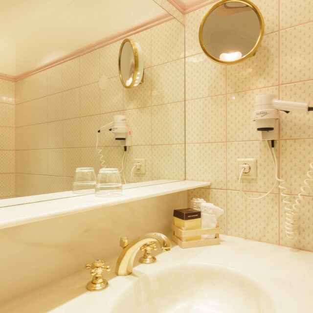 einzelzimmer waldblick2 Elegantes Badezimmer mit Spiegel und Haartrockner.