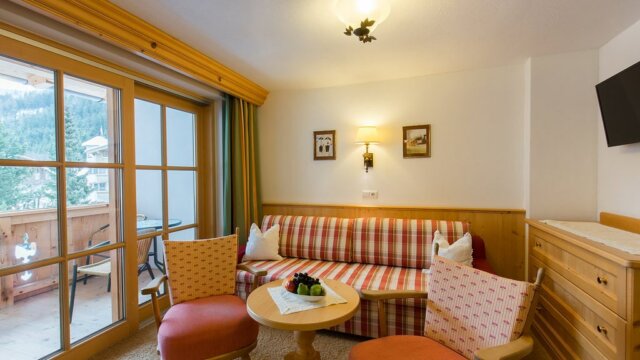 Gemütliches Wohnzimmer mit Balkon und Fernseher.