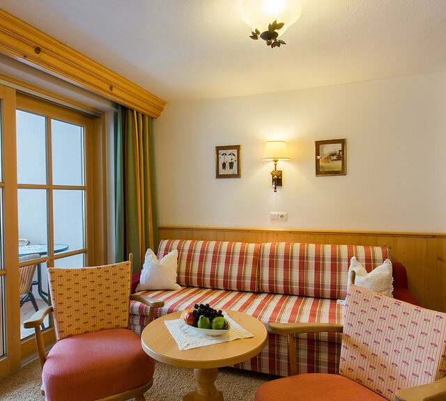 Gemütliches Wohnzimmer mit Balkon und Fernseher.