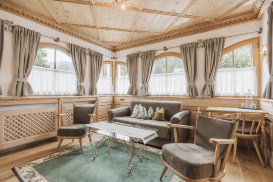 Gemütliches Wohnzimmer mit Holzdekor und Fenstern.