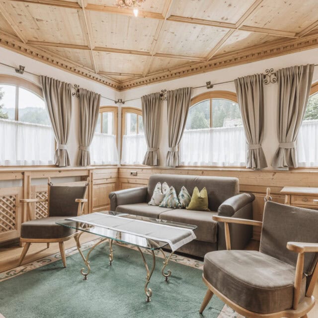 Gemütliches Wohnzimmer mit Holzdekor und Fenstern.