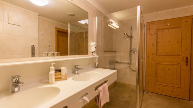 Helles Badezimmer mit Dusche und Holzdetails.