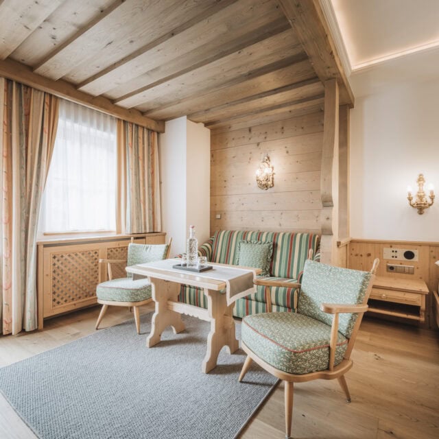 juniorsuite fürstalm2 Gemütlicher Wohnbereich mit Holz- und Stoffelementen