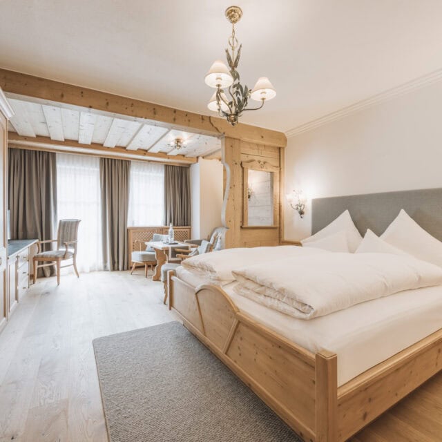 juniorsuite fürstalm3 Gemütliches Zimmer mit Holzmöbeln und Tageslicht.