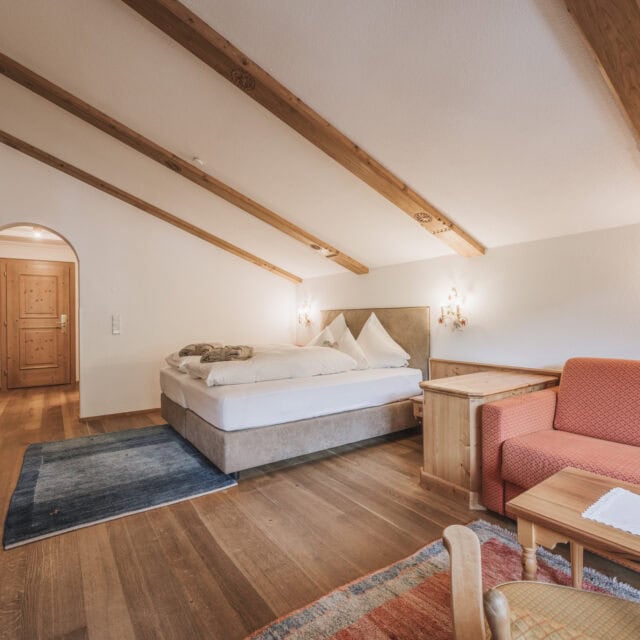 juniorsuite fürstalm7 Gemütliches Schlafzimmer mit Holzdecke und Möbeln