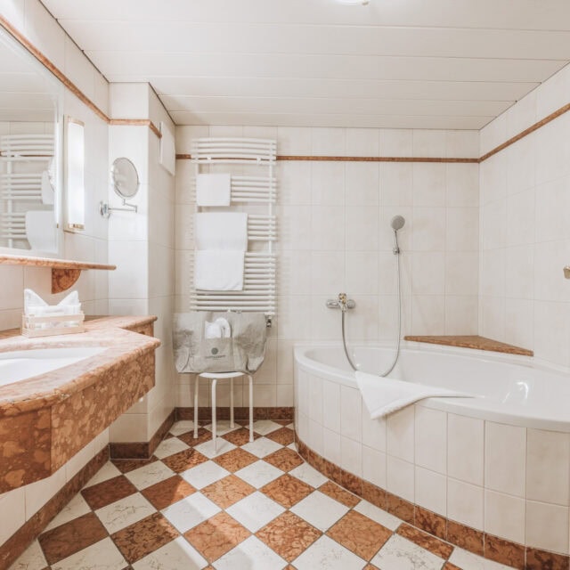 juniorsuite fürstalm8 Helles Bad mit Badewanne und Waschbecken