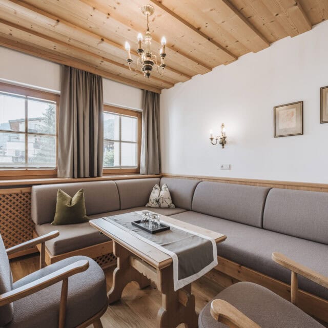 Gemütliches Wohnzimmer mit Holzverkleidung und Fenstern