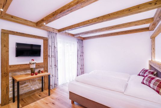 Helles Schlafzimmer mit Holzdetails und Fernseher