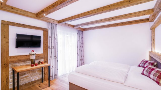 Helles Schlafzimmer mit Holzdetails und Fernseher