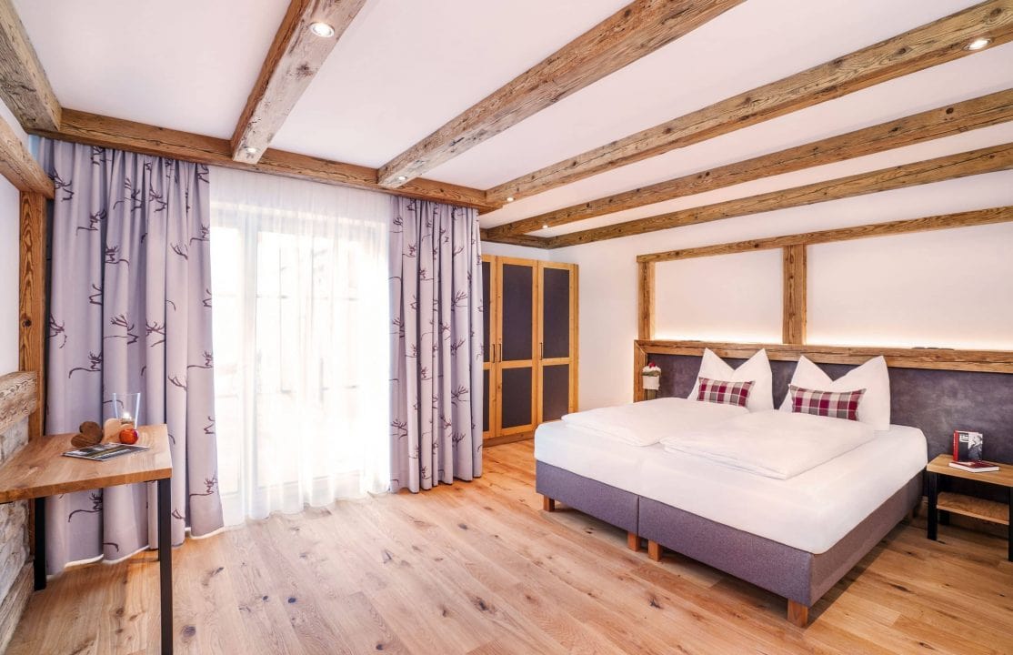 Helles Zimmer mit Holzdetails und komfortablem Bett.
