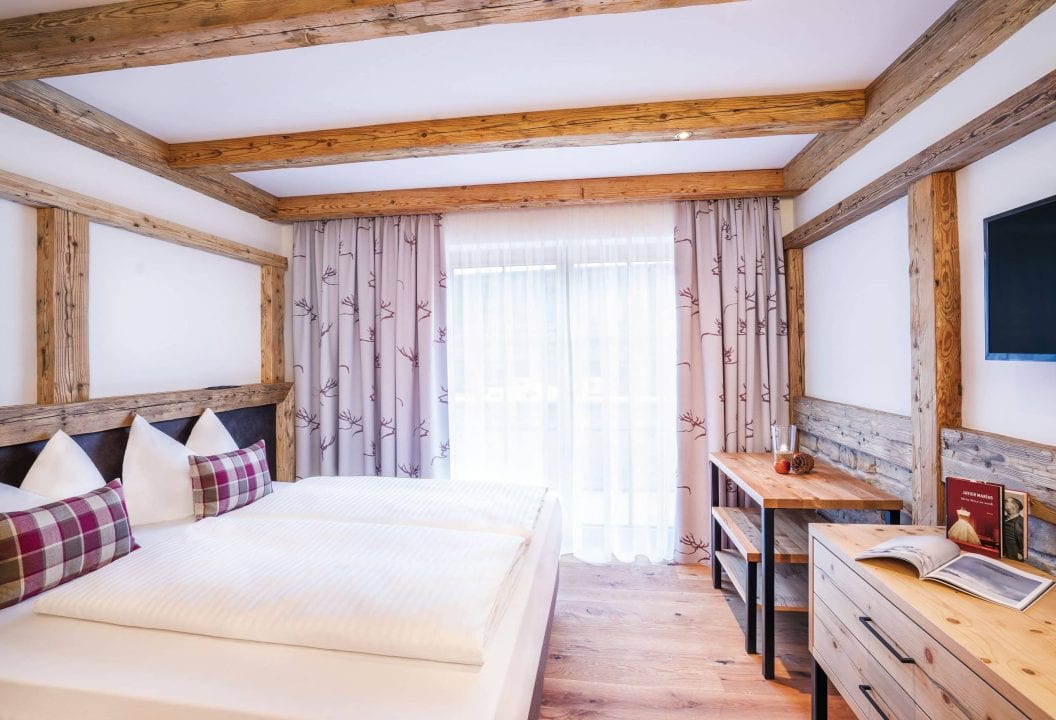 Gemütliches Zimmer mit Doppelbett und Holzdekor.