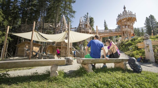 Spielplatz mit Holzstrukturen und Familienaktivitäten