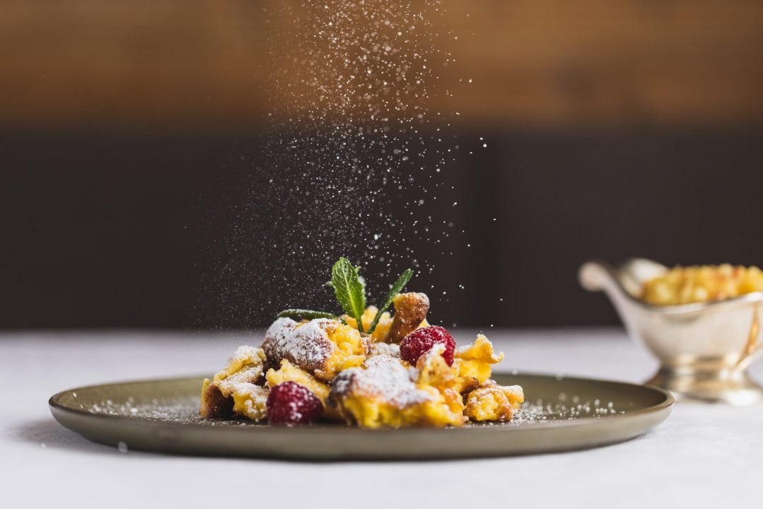 Leckeres Dessert mit Früchten und Puderzucker.