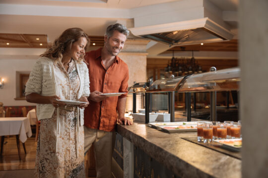 Paar am Buffet, lächelnd und glücklich.