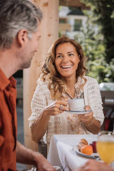 Lächelnde Frau bei einem entspannenden Frühstück.
