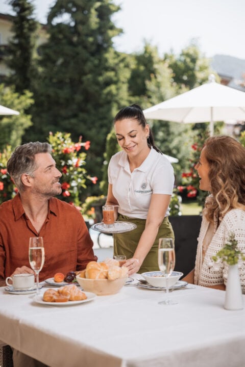 Frühstücksservice im Freien mit Gästen.