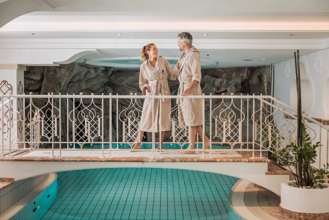 Paar in Bademänteln am Pool