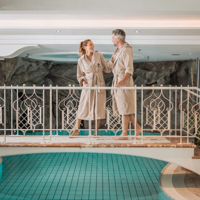 Paar in Bademänteln am Pool