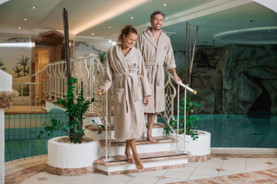Paar in Bademänteln am Poolbereich