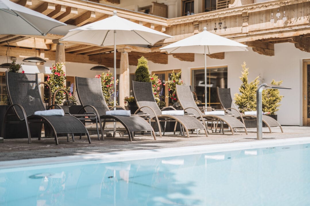 Bequeme Liegen am Pool in sonniger Umgebung