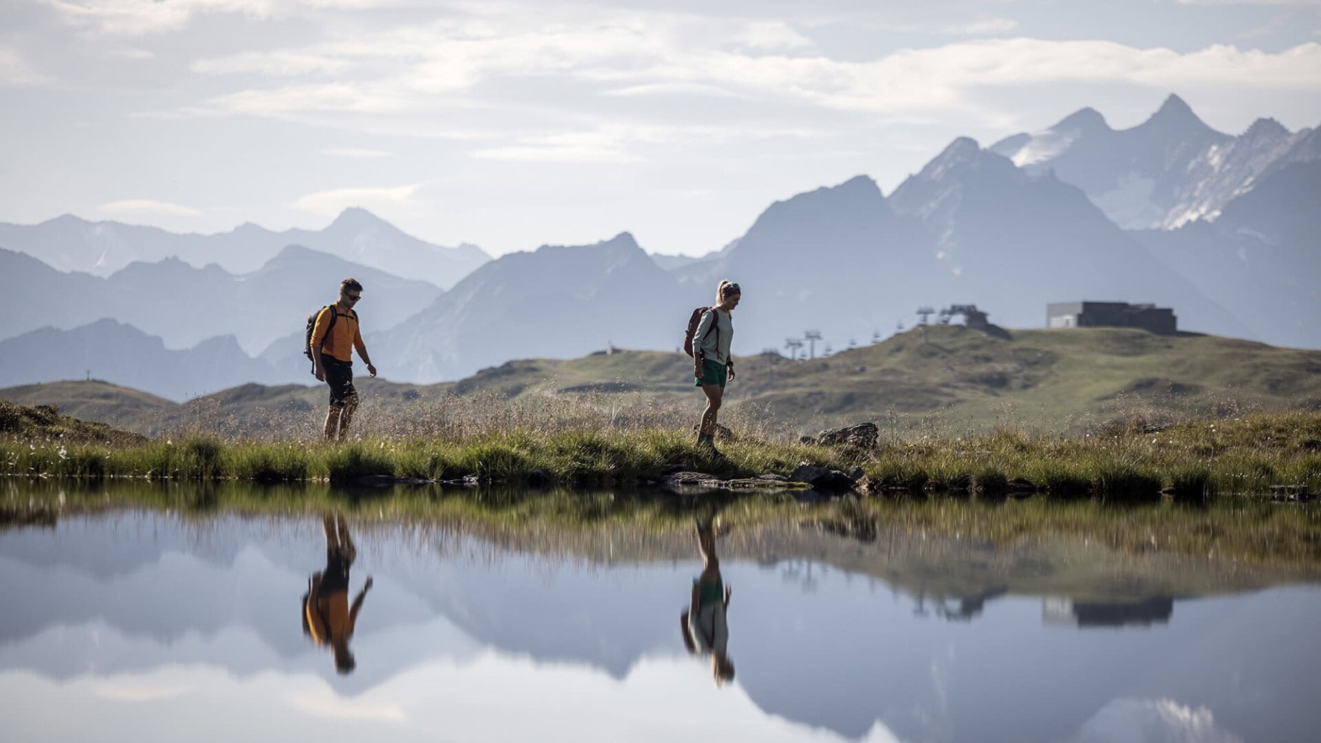 Wanderer am See vor Berglandschaft
