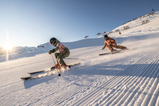 Skifahrer auf sonnigen Pisten im Schnee