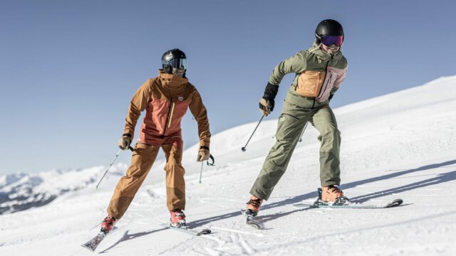 Zwei Skifahrer auf verschneiter Piste