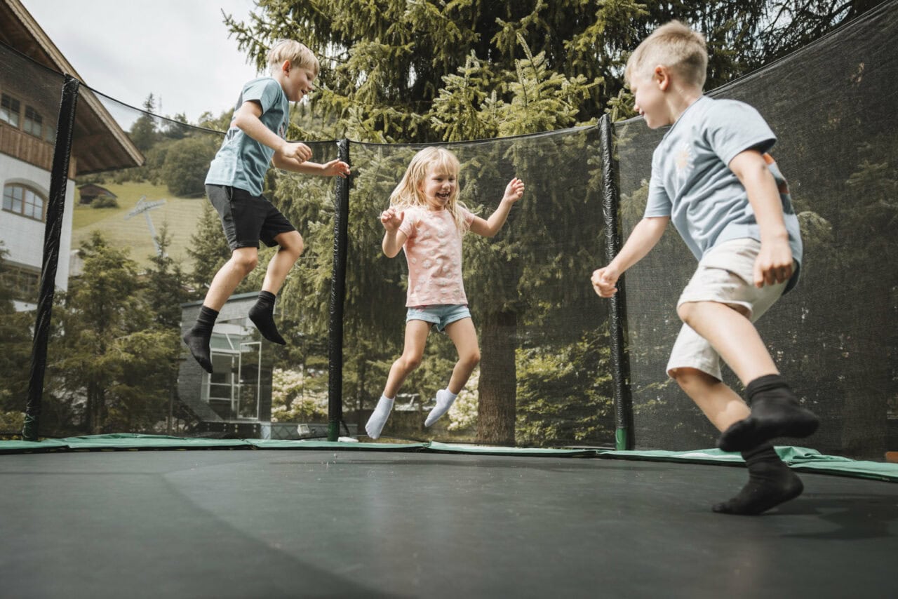 Kinder springen fröhlich auf einem Trampolin.
