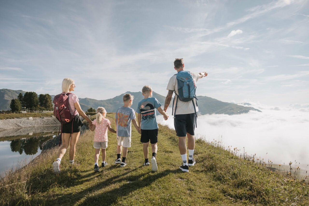 Familie wandert auf einem Wanderweg in der Natur.