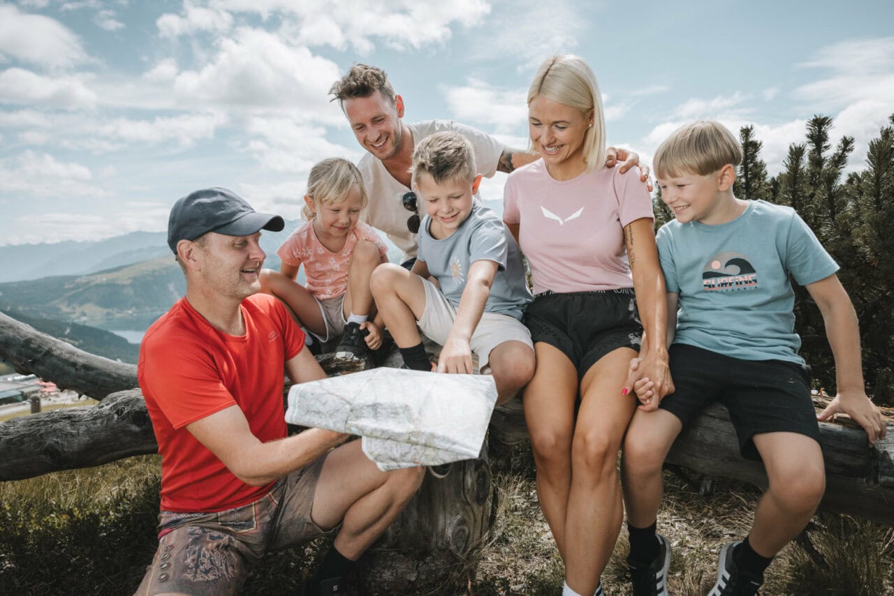 Familie betrachtet eine Landkarte im Freien