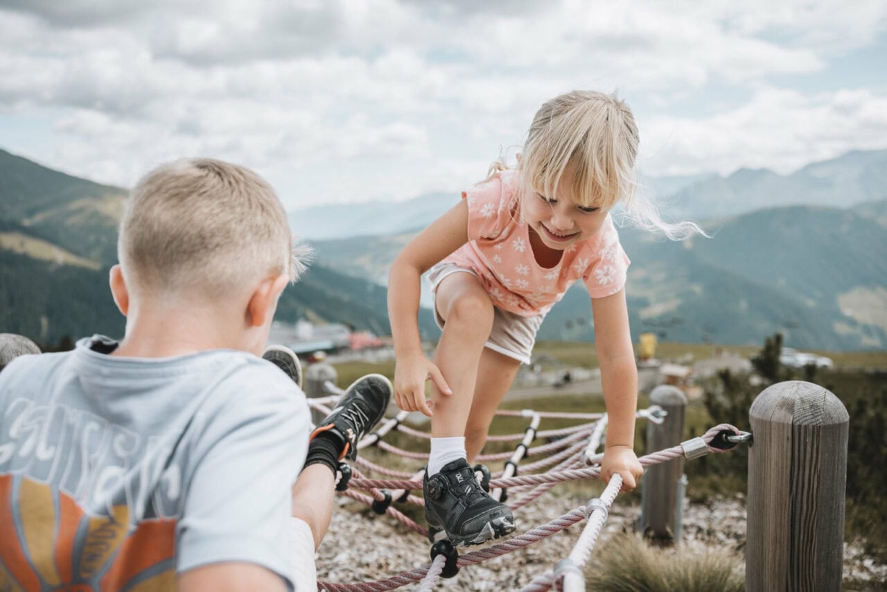 Kinder spielen auf einem Klettergerüst in den Bergen.